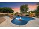 Inviting pool area featuring a rock waterfall, lush landscaping, and a serene ambiance for relaxation and recreation at 3523 E Presidio Cir, Mesa, AZ 85213
