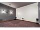 Home theater room features tiered seating, sconces, and surround sound speakers at 3523 E Presidio Cir, Mesa, AZ 85213