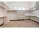 Bright walk-in closet with custom shelving, carpeted floor, and three windows for natural light at 3523 E Presidio Cir, Mesa, AZ 85213