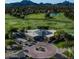 Aerial view of the golf course and clubhouse with trees and a pond in the background at 3650 E Laurel Ln, Phoenix, AZ 85028