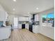 Bright kitchen boasts white cabinets, black appliances, stylish backsplash, and light wood floors at 3650 E Laurel Ln, Phoenix, AZ 85028
