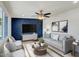 Comfortable living room features modern decor, stylish furniture, ceiling fan, and decorative blue accent wall at 3650 E Laurel Ln, Phoenix, AZ 85028