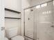 Bathroom featuring walk in shower, white toilet, floating shelves and a large sliding glass door at 3756 E Kerry Ln, Phoenix, AZ 85050