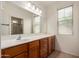 Bright bathroom featuring wood cabinets, a large mirror and shower with glass door at 3756 E Kerry Ln, Phoenix, AZ 85050