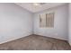 Simple bedroom includes carpet flooring, a neutral wall color, and a bright window at 3756 E Kerry Ln, Phoenix, AZ 85050