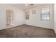 A cozy bedroom featuring carpet flooring, an arched doorway, and two bright, window views at 3756 E Kerry Ln, Phoenix, AZ 85050