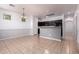 Open-concept kitchen and dining area with neutral tile, black cabinets, and a breakfast bar at 3756 E Kerry Ln, Phoenix, AZ 85050