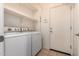 Practical laundry room with washer, dryer, and storage shelves at 3756 E Kerry Ln, Phoenix, AZ 85050