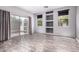 Bright living room with stylish wood laminate flooring, built-in shelving, and sliding glass door to the patio at 3756 E Kerry Ln, Phoenix, AZ 85050
