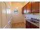 Well-lit laundry room featuring tile floors, window, and wood cabinets above the counter and sink at 4241 E Andre Ave, Gilbert, AZ 85298