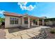 Expansive backyard featuring a covered patio, flagstone walkways, desert landscaping, and views of the well-maintained property at 4446 E Woodridge Dr, Phoenix, AZ 85032