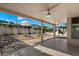 Covered patio overlooking a landscaped backyard with stone pavers, rock features, and mature trees providing shade and privacy at 4446 E Woodridge Dr, Phoenix, AZ 85032