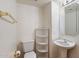 Cozy powder room featuring pedestal sink, corner shelves, and a rectangular mirror at 4446 E Woodridge Dr, Phoenix, AZ 85032