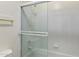 Bathroom featuring tub and shower combo with sliding glass door and white tiling at 4446 E Woodridge Dr, Phoenix, AZ 85032
