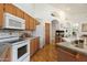 Traditional-style kitchen featuring wood cabinetry, granite countertops, and modern white appliances at 4446 E Woodridge Dr, Phoenix, AZ 85032