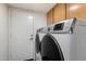 Laundry area showcases front load washer and dryer alongside cabinets, and a door to outside at 4446 E Woodridge Dr, Phoenix, AZ 85032