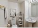 Bright powder room featuring a pedestal sink, white fixtures, and decorative accents at 4446 E Woodridge Dr, Phoenix, AZ 85032
