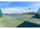 A full-sized tennis court complex features well-maintained blue courts, lighting, and secure fencing under a bright blue sky at 5735 E Mcdowell Rd # 147, Mesa, AZ 85215