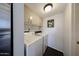 Bright laundry room with stacked washer and dryer, neutral cabinetry, and tile floor at 6533 N 10Th Pl, Phoenix, AZ 85014