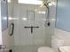 Modern bathroom with stylish glass shower, black hardware, and flower-patterned tile flooring at 6687 S Banning St, Gilbert, AZ 85298