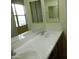 Dual-sink bathroom vanity with modern faucets and expansive mirror at 6687 S Banning St, Gilbert, AZ 85298
