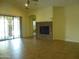 Bright living room features stone fireplace, tile floors, and sliding glass doors to patio at 6687 S Banning St, Gilbert, AZ 85298