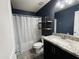 Bathroom featuring granite countertops, dark cabinetry, wood-look tile flooring, and decorative shelves at 7312 S 13Th Way, Phoenix, AZ 85042