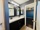 Bathroom featuring granite countertops, dual sinks, dark cabinetry, and wood-look tile flooring at 7312 S 13Th Way, Phoenix, AZ 85042