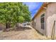 View of the backyard and side of a tan home with a large tree providing shade at 863 S Del Rancho --, Mesa, AZ 85208