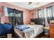 Bedroom with pink walls, wood floors, and a dark wood headboard bed at 8724 N 28Th Ave, Phoenix, AZ 85051