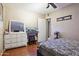 Bedroom features wood floor, ceiling fan, and a dresser with mirror at 8724 N 28Th Ave, Phoenix, AZ 85051