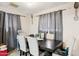 Dining room with a dark wood table, upholstered chairs, gray curtains, and tile flooring at 8724 N 28Th Ave, Phoenix, AZ 85051