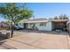 Charming single-story home with blue exterior, decorative rock yard, large carport and a long driveway at 8724 N 28Th Ave, Phoenix, AZ 85051