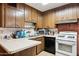 Functional kitchen with wood cabinets, white appliances, and ample counter space at 8724 N 28Th Ave, Phoenix, AZ 85051