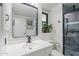 Modern bathroom features a black framed mirror, white vanity, and a walk-in shower at 10644 W Campana Dr, Sun City, AZ 85351