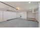 Well-lit garage with epoxy floors, built-in storage cabinets, washer/dryer, and ample space for parking or hobbies at 10644 W Campana Dr, Sun City, AZ 85351