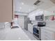 Renovated kitchen with stainless steel appliances, white cabinetry, and quartz countertops at 10644 W Campana Dr, Sun City, AZ 85351
