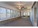 Enclosed sun room with many windows, brick base, and a ceiling fan at 10644 W Campana Dr, Sun City, AZ 85351