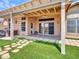 Covered back patio overlooking a lawn, landscaping, and back of house at 11547 W King Snake Ct, Surprise, AZ 85378
