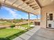Inviting covered back patio with artificial grass, desert landscaping, and hot tub at 11547 W King Snake Ct, Surprise, AZ 85378