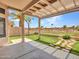 Inviting covered back patio featuring an artificial grass lawn, desert landscaping and golf course views at 11547 W King Snake Ct, Surprise, AZ 85378