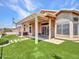 Spacious backyard featuring artificial grass, covered patio and desert landscaping at 11547 W King Snake Ct, Surprise, AZ 85378
