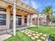 Backyard featuring desert landscaping, artificial grass, and a covered patio at 11547 W King Snake Ct, Surprise, AZ 85378