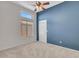 Neutral bedroom showcasing a fan, large window, and plush carpet flooring at 11547 W King Snake Ct, Surprise, AZ 85378