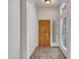 Light-filled foyer featuring beautiful wood door, ceramic tile floors, and a modern light fixture at 11547 W King Snake Ct, Surprise, AZ 85378
