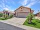 Traditional home offers a spacious driveway, attached garage, and green lawn at 11547 W King Snake Ct, Surprise, AZ 85378