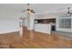 Open-concept kitchen with wood floors flowing into tile and stainless steel appliances at 11547 W King Snake Ct, Surprise, AZ 85378