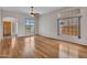 Bright living room featuring hardwood floors, arched doorway, ceiling fan, and large windows at 11547 W King Snake Ct, Surprise, AZ 85378