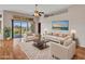 Bright living room with neutral tones, wood floors, and large sliding glass doors to the backyard at 11547 W King Snake Ct, Surprise, AZ 85378