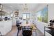 Bright dining area with blonde wood table, modern lighting fixture, and expansive windows showcasing a scenic view at 13020 N 18Th St, Phoenix, AZ 85022